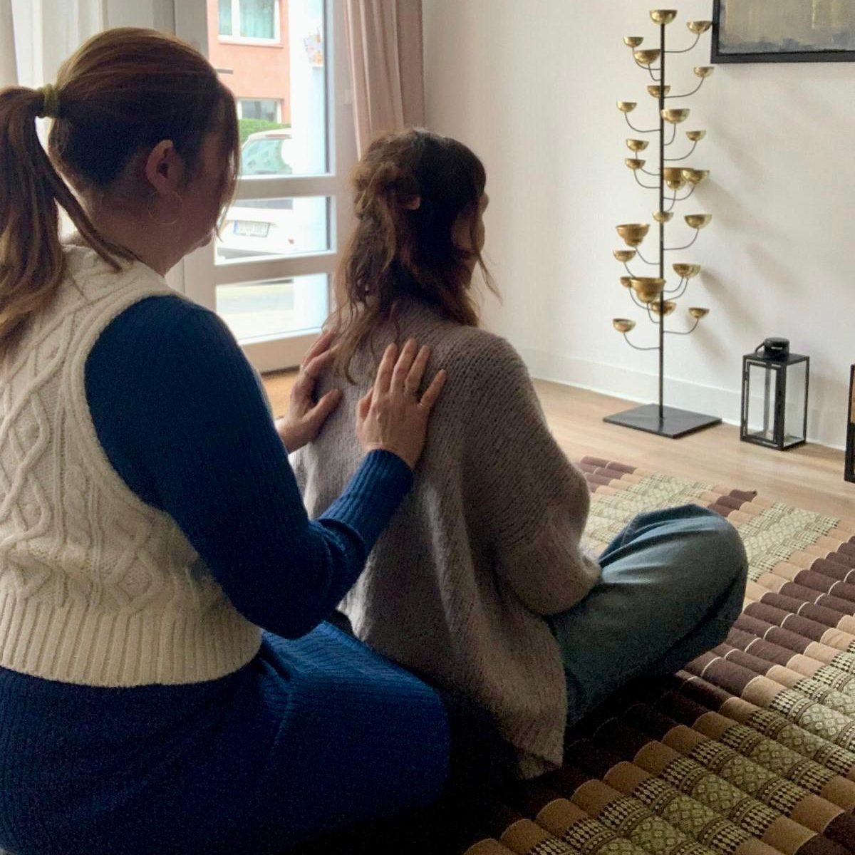 Bunte Trockenblumen mit Kerzen und unscharfen Lichtern im Hintergrund.