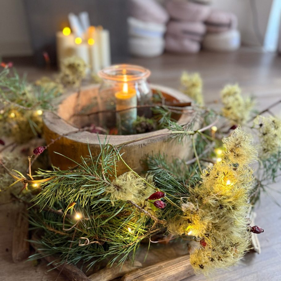 Zwei Tassen Tee auf einem bunten Tisch mit Früchten und frischen Kräutern.