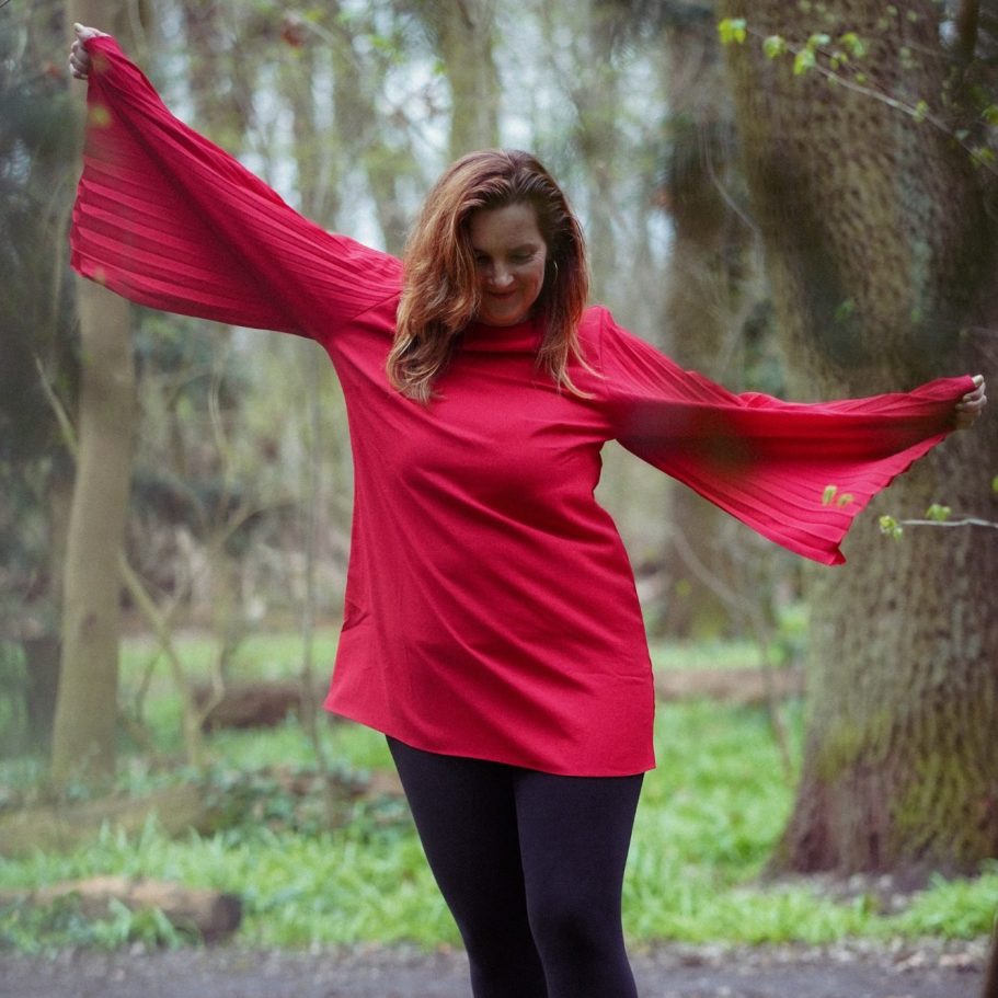 Portrait einer lächelnden Frau mit langen, braunen Haaren und dunklem Kopftuch.