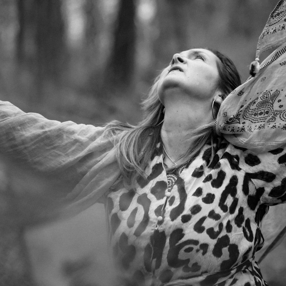 Portrait einer lächelnden Frau mit langen, braunen Haaren und dunklem Kopftuch.