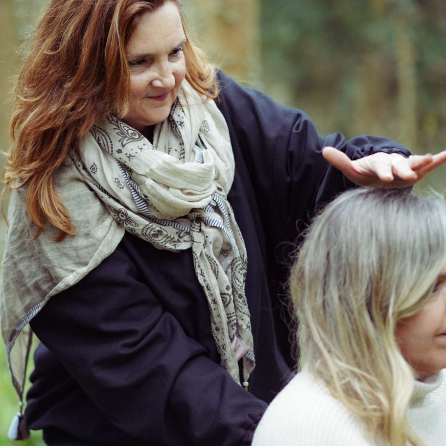 Eine Frau frisiert das Haar einer anderen Frau im Freien.