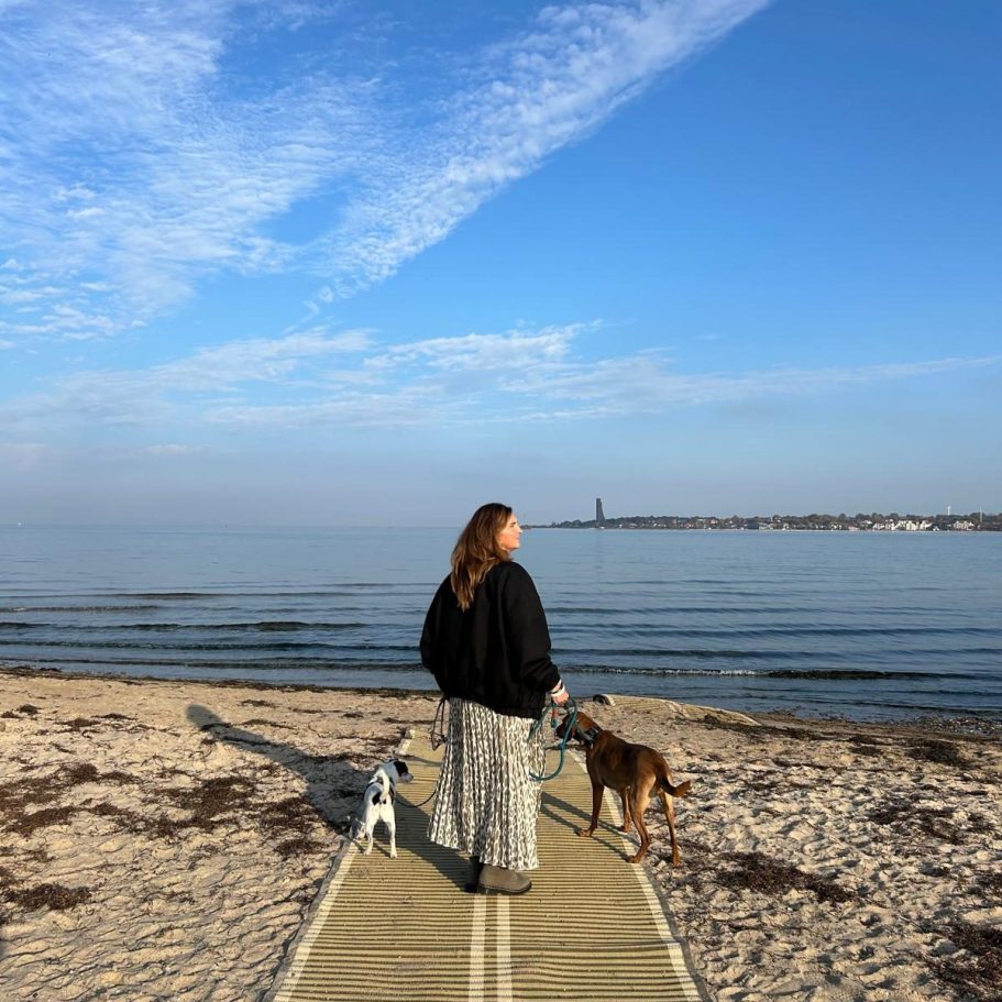 Portrait einer lächelnden Frau mit langen, braunen Haaren und dunklem Kopftuch.